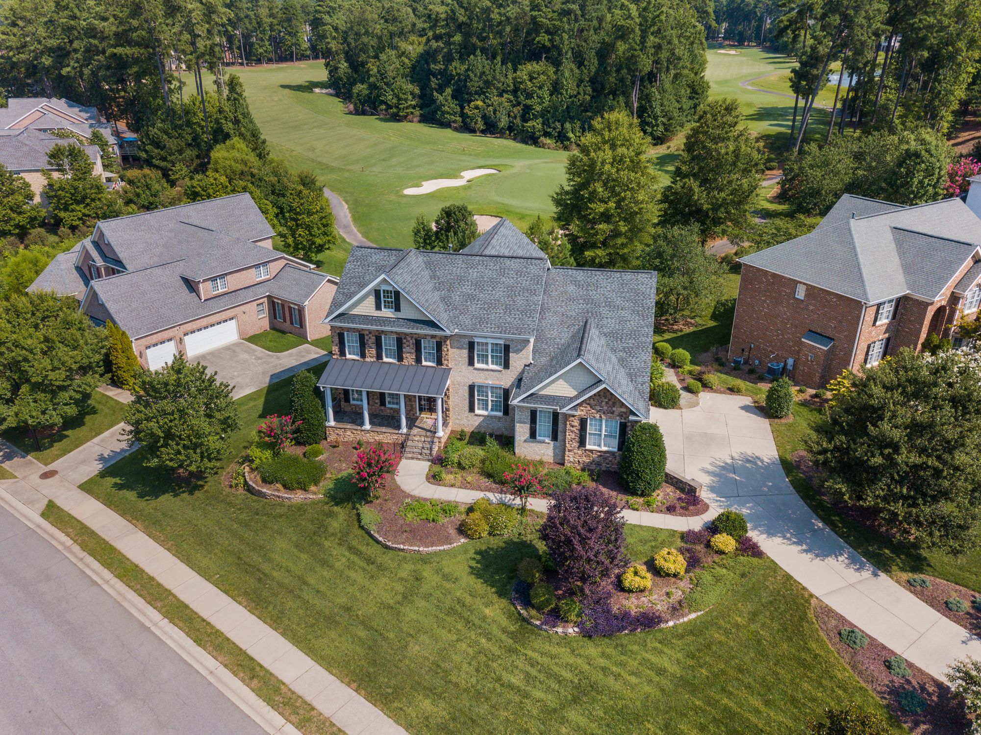 Aerial view of a suburban neighborhood with tree-lined streets and homes, representing Apex, NC